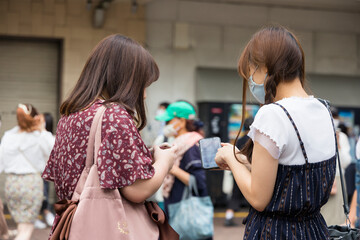 渋谷駅前でスマホを見る女性の二人組