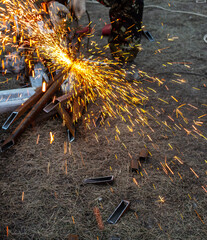 A worker cuts metal at a construction site. Technology