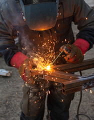 A worker welds metal for a canopy.