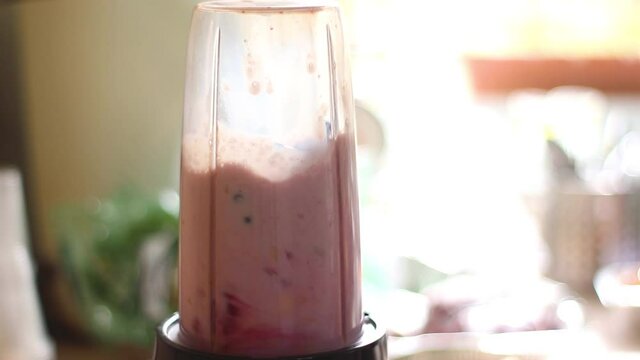 A closer look at making a protein shake with bananas milk and berries, after a workout
