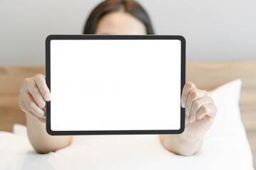 Woman hand holding with a digital tablet on the bed.