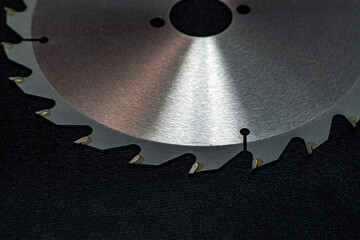 circular saw disk on a black background. circular saw blade on wood