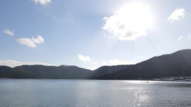 Lake Yogo in Shiga Prefecture in winter, the surface of the pond illuminated by the strong sunlight.