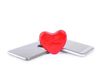 Red heart and two smartphones isolated on white. Selective focus. Close-up. Online dating, online communication. Copy space.