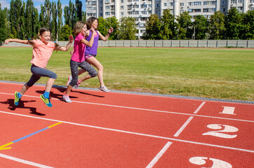 Family fitness, mother and kids running on stadium track, exercise with children  and sport healthy...