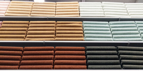 Stacked many colors folded multicolored towels on shelves