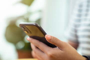 Woman holding a smartphone and using social media on internet.