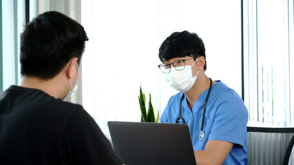 Asian man doctor wear protection face mask during coronavirus and flu outbreak is taking care examining sick patient in hospital