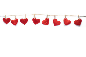 Clothespins and red hearts on a rope isolated on white background. Valentine's Day.