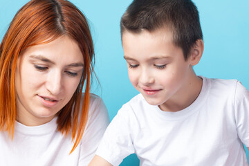 Close-up mom with her son doing homework on a blue background. Home education