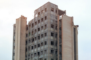 Crumbling emergency skeleton of destroyed building with broken windows for demolition