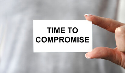 The girl holds a card with a time to compromise tact, a background grey T-shirt.