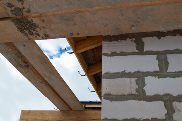 close up view of scaffolding and house under construction with holders for gutters water drainage system of roof