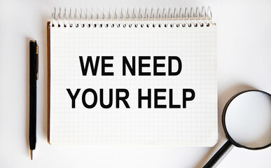 In the notebook the text we NEED YOUR HELP, next to the magnifying glass and pen.