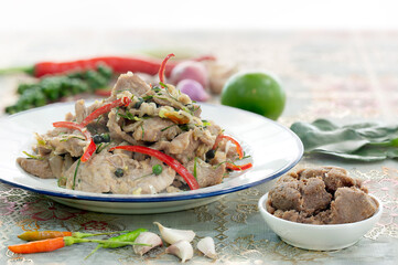 Fried pork with shrimp paste in white dish Thai food on old brown wooden table