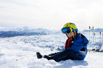 Fototapeta na wymiar Cute little boy, skiing happily in Austrian ski resort in the mountains