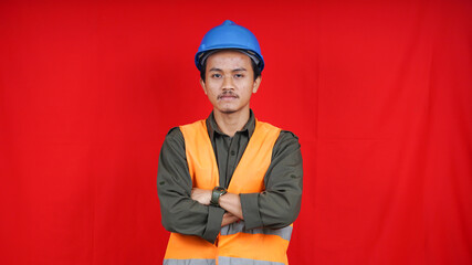 asian worker man wearing uniform and helmet isolated red background