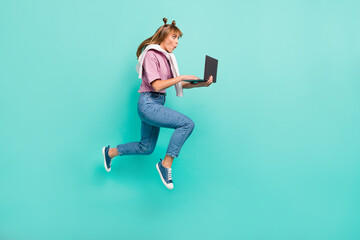Full body profile side photo of young girl amazed surprised jump up browse laptop isolated over teal color background