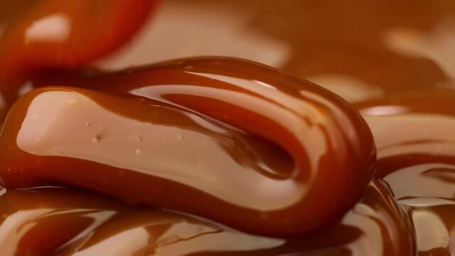Caramel dripping thick strand. Slow motion.