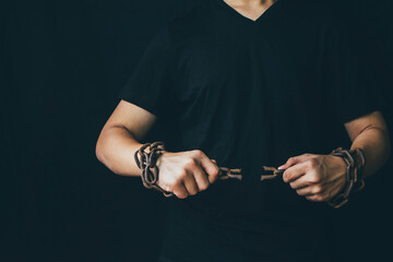 Close up  of a man hands was pulling and broke the rusty metal chain which tied by his hands