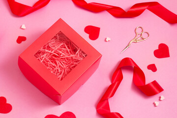 Top view of Gift box packing on pink color table. Valentines day decor ribbons and hearts