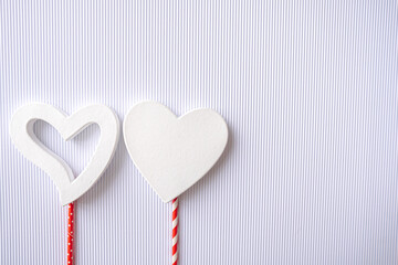 Festive postcard flatlay on Valentine's Day. Large 3D white hearts on a white background with red bright legs