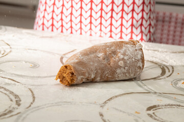 Women's hands roll out brown dough for gingerbread cookies