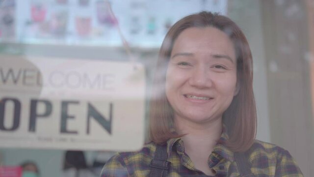 Happy woman coffee shop owner standing near cafe door entrance with arms crossed while looking at camera and smiling. Small business concept.
