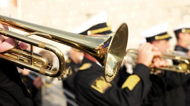 A wind instrument - a unrecognizable military man is playing trumpet, close-up. High quality 4k footage