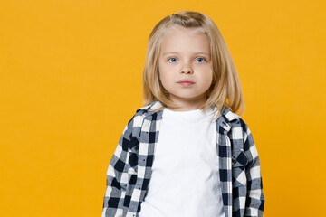 Little cute fun happy blond long-haired kid boy 5 years old wearing casual clothes posing isolated on bright yellow wall color background children studio portrait. People childhood lifestyle concept