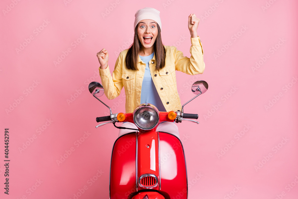 Poster Photo of young excited happy amazed woman girl female raise fists ride red motorbike isolated on pink color background