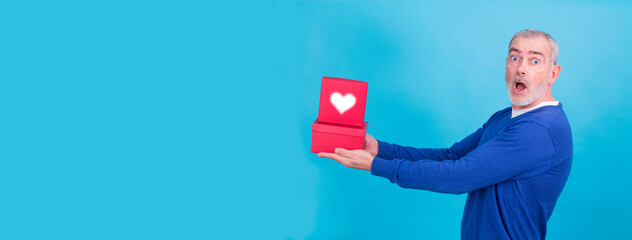 casual senior man with gift box on blue background