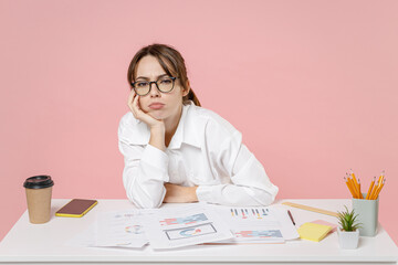 Boring tired young business woman employee in shirt glasses put hands prop up on chin working in...
