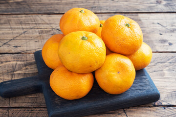 Oranges tangerines or mandarins clementines, citrus fruits on rustic wooden background, copy space.
