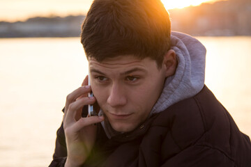 smiling man using mobile phone by the sea