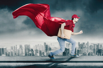 Male courier wearing red cape while holding a box
