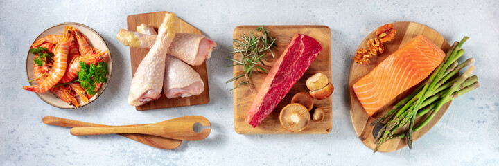 Balanced diet. Main proteins and some garnishes, overhead flat lay panorama with wooden spoons