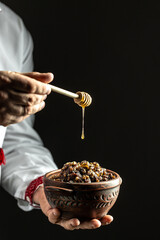kutya. hand pours honey. Christmas Slovenian food, vertical image, place for text
