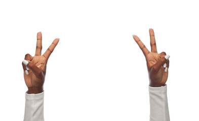 gesture and people concept - hands of african american woman showing peace sign on white background