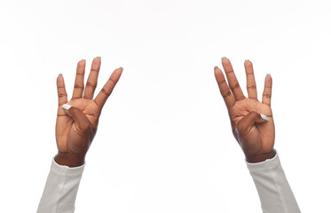 gesture and people concept - hands of african american woman showing eight fingers on white background