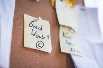 Employee motivation and leadership concept. “Great work” note on pinned paper, cork board