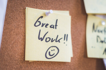 Employee motivation and leadership concept. “Great work” note on pinned paper, cork board
