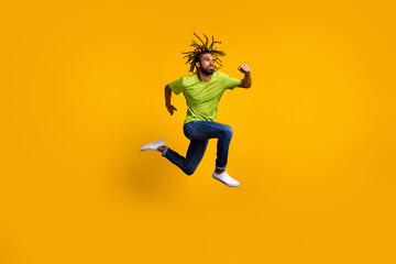Fototapeta na wymiar Photo portrait full body view of determined runner jumping up isolated on vivid yellow colored background