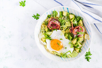 Ketogenic, paleo diet. Fried egg, prosciutto, avocado and fresh salad.  Keto breakfast. Brunch.  Top view, overhead, flat lay
