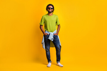 Fototapeta na wymiar Full size photo of young handsome man happy positive smile hands in pocket summer travel wear denim isolated over yellow color background