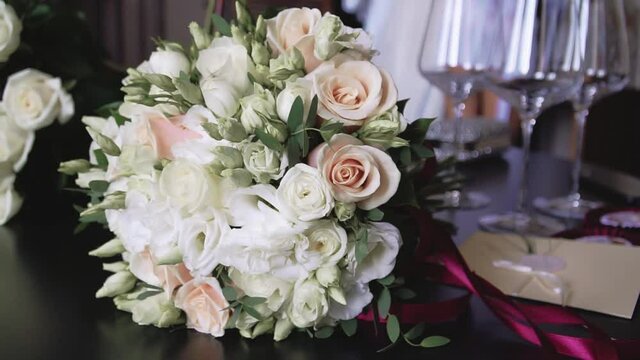 Bouquet of white roses on the background of wine glasses