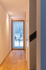 Hallway with white wall and windows with view of nature and snow