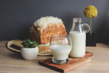 A bottle of milk and glass of milk with blurry background whole wheat bread with grated cheese on top