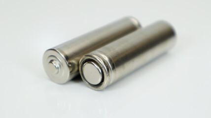 AA alkaline rechargeable batteries on white glossy background with reflection. Close up two empty batteries with copy space.