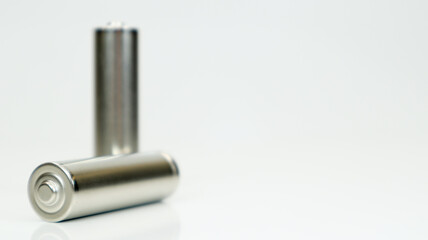 AA alkaline rechargeable batteries on white glossy background with reflection. Close up two empty...